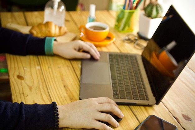 Sección media de un hombre usando una computadora portátil en la mesa