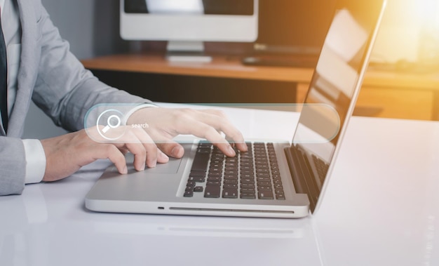 Sección media de un hombre usando una computadora portátil en la mesa