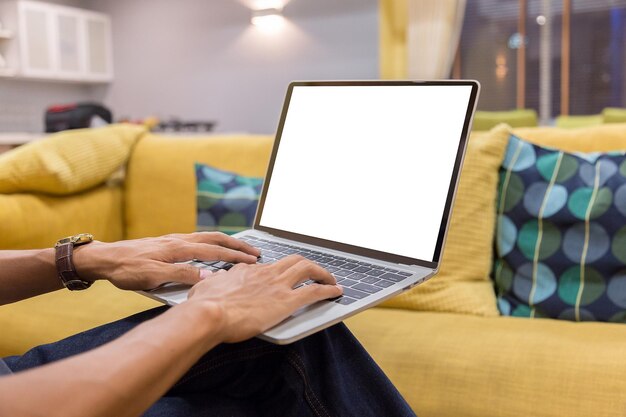 Sección media de un hombre usando una computadora portátil mientras está sentado en la mesa