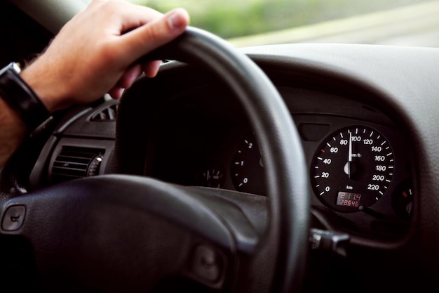 Sección media de un hombre usando un teléfono inteligente en un coche