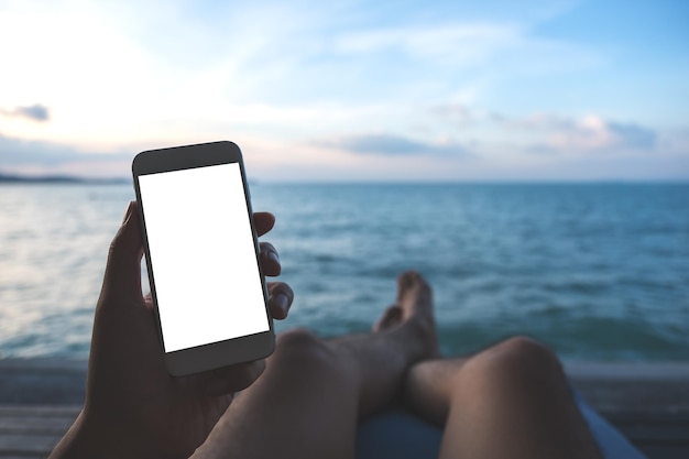 Foto sección media de un hombre usando un teléfono móvil contra el mar