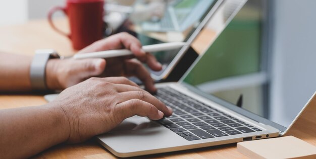 Sección media de un hombre usando un teléfono móvil en la mesa