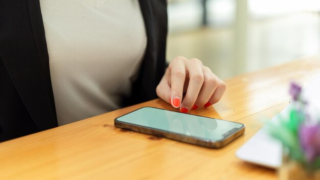 Sección media de un hombre usando un teléfono móvil en la mesa