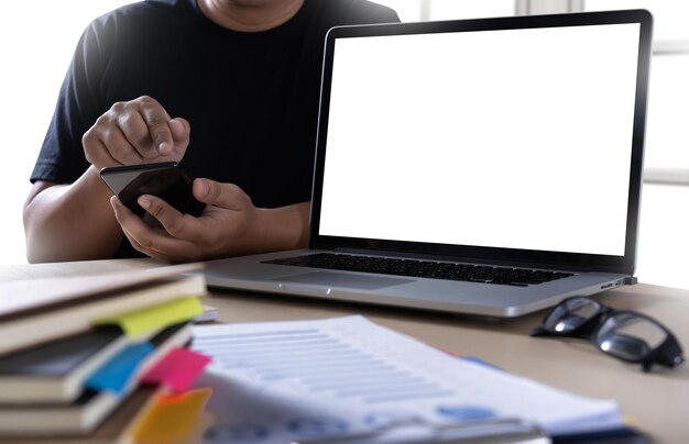 Sección media de un hombre usando el teléfono móvil en la mesa