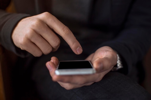 Sección media de un hombre usando un teléfono móvil