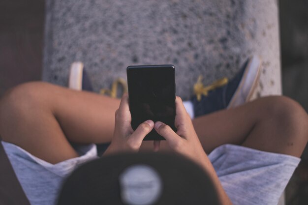 Sección media de un hombre usando un teléfono móvil