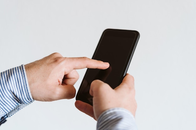 Sección media de un hombre usando un teléfono móvil