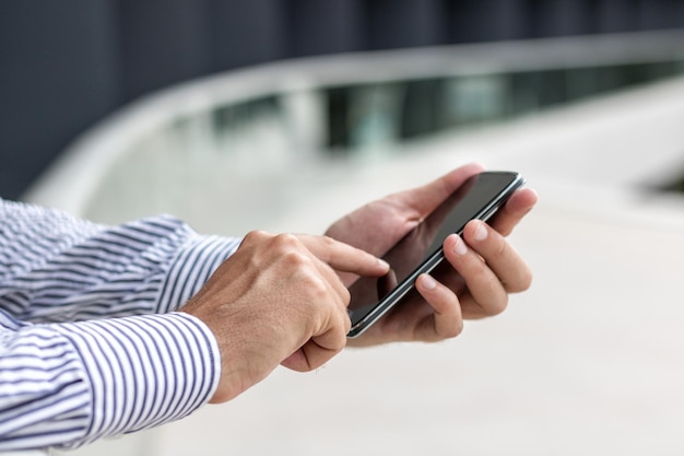 Sección media de un hombre usando un teléfono móvil