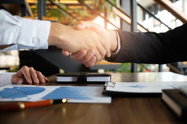 Foto sección media de hombres de negocios y colegas estrechando la mano en la oficina