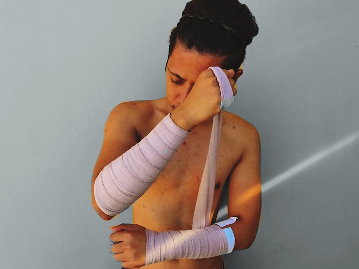 Foto sección media de un joven envolviendo los brazos en vendajes