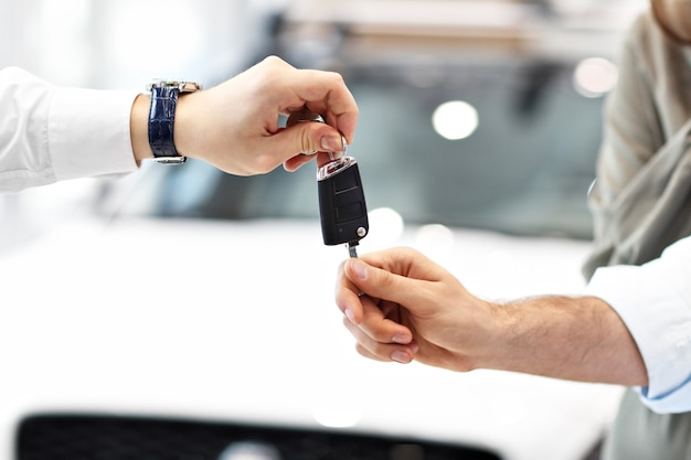 Sección media de la joven pareja comprando un coche nuevo en el showroom