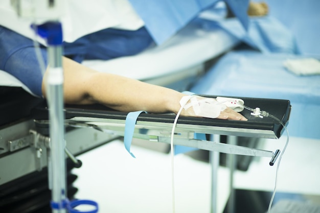 Sección media de la mano del paciente inyectada con goteo intravenoso en el hospital