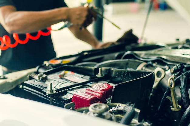 Sección media de un mecánico reparando un coche en el garaje