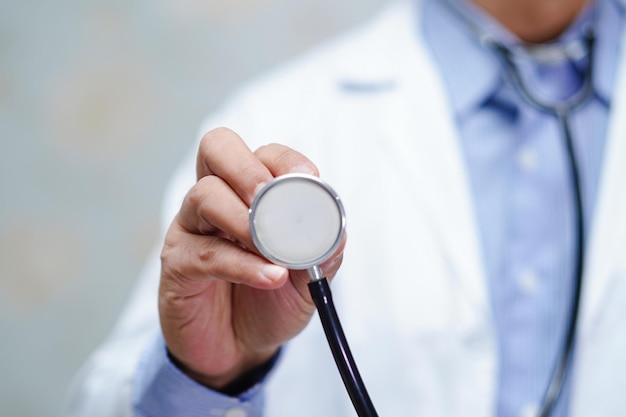 Sección media del médico con el estetoscopio en la mano en la clínica