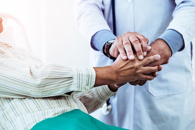 Sección media del médico y el paciente tomados de la mano