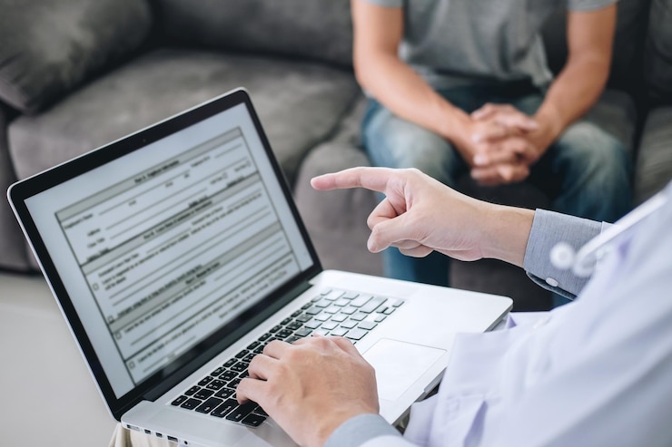 Foto sección media del médico con el paciente usando una computadora portátil en casa