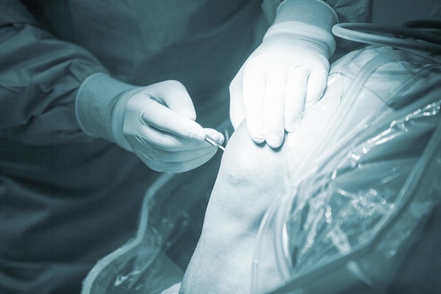 Sección media del médico que realiza una operación en la rodilla del paciente en el hospital