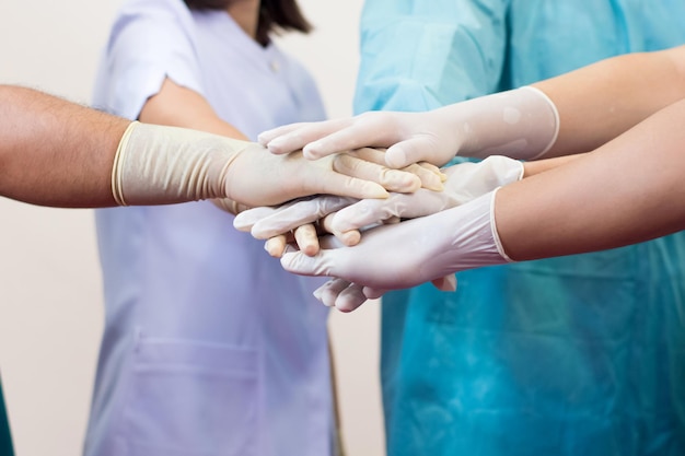 Sección media de médicos apilando las manos