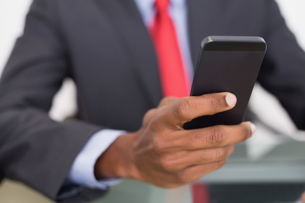 Sección media del mensaje de texto bien vestido del hombre de negocios