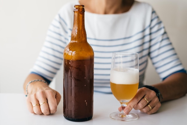 Foto sección media de una mujer con una bebida en la mesa