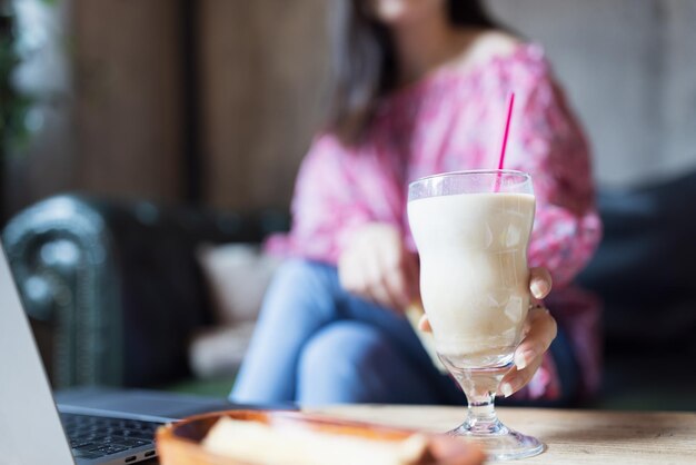 Foto sección media de una mujer bebiendo un vaso en la mesa