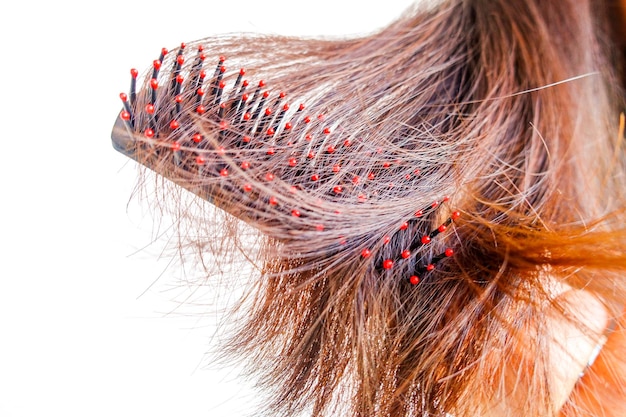 Foto sección media de una mujer cepillando el cabello contra un fondo blanco