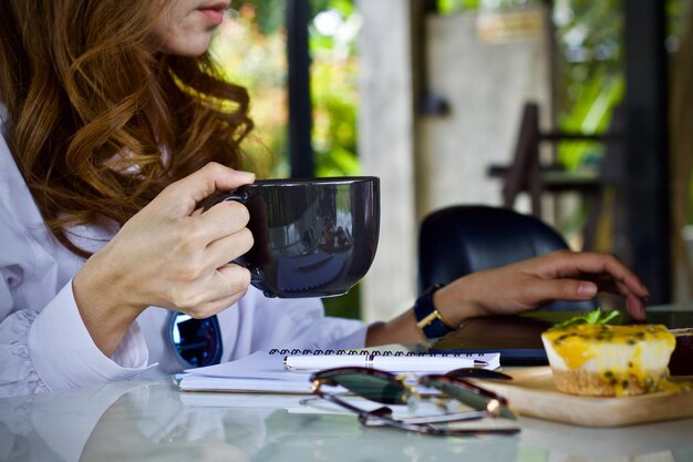 Foto sección media de una mujer comiendo y bebiendo en el interior