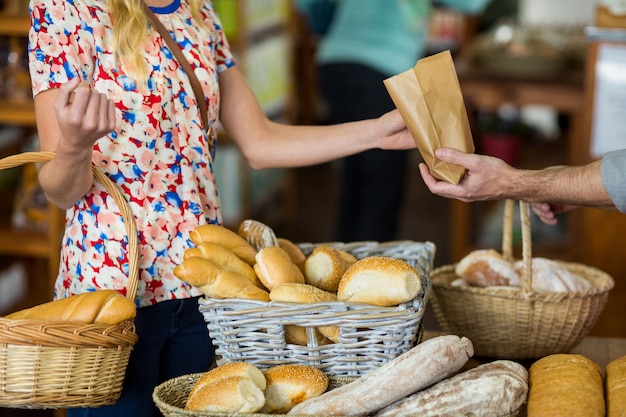 Sección media de mujer comprando pan
