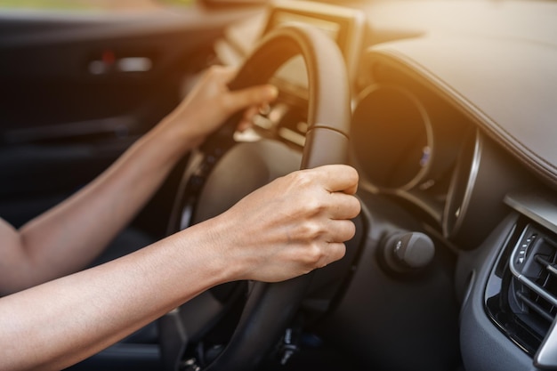 Sección media de una mujer conduciendo en un coche