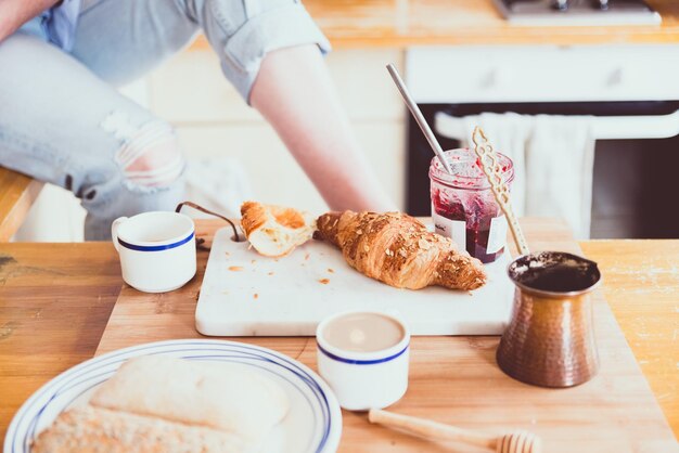 Foto sección media de una mujer con el desayuno en la mesa