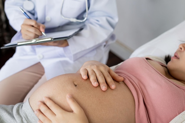 Foto sección media de una mujer embarazada con un médico en el hospital