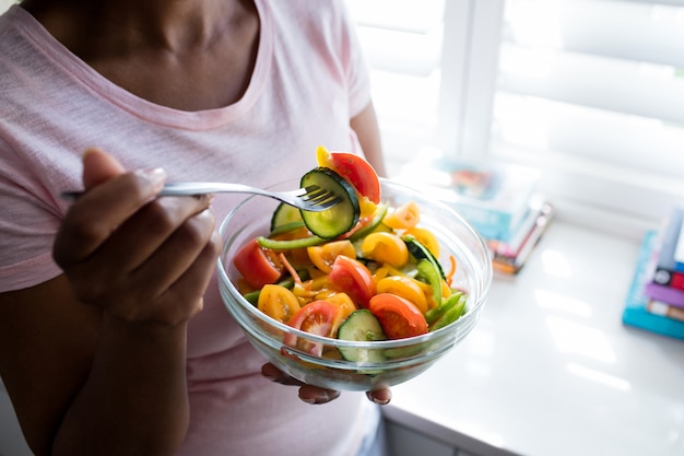 Sección media de mujer con ensalada