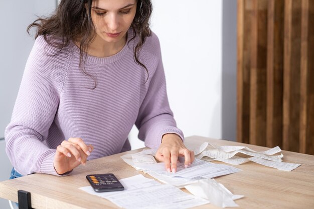 Foto sección media de una mujer escribiendo en un libro en casa