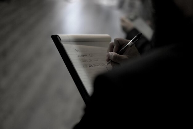 Foto sección media de una mujer escribiendo en un libro