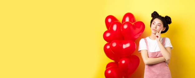 Foto sección media de una mujer con forma de corazón contra un fondo amarillo