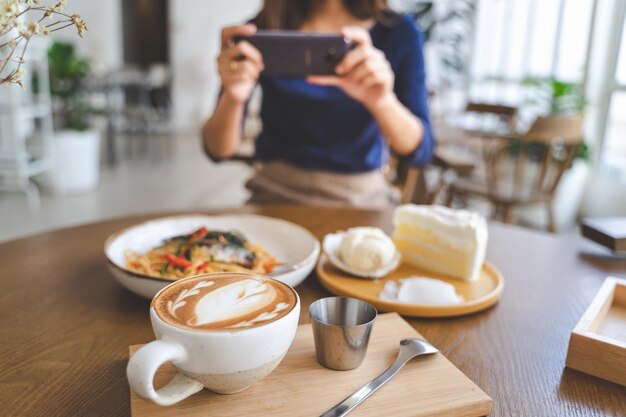 Foto sección media de una mujer fotografiando comida usando un teléfono