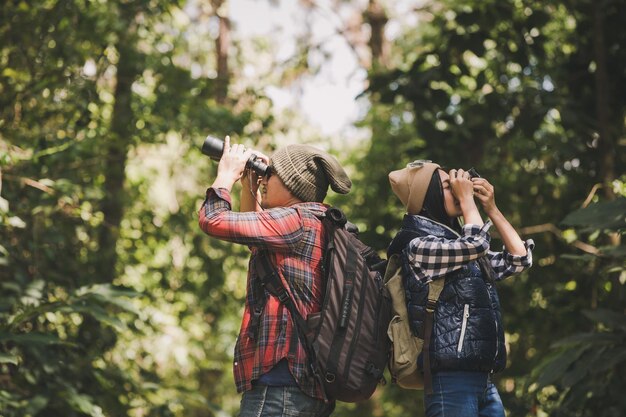 Foto sección media de una mujer fotografiando contra los árboles en el bosque