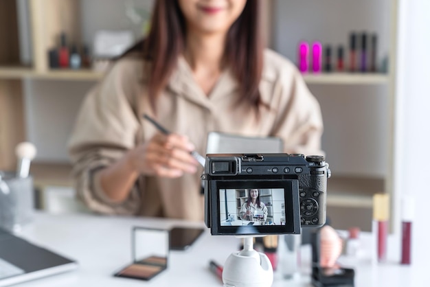 Sección media de una mujer fotografiando con un teléfono inteligente en la mesa