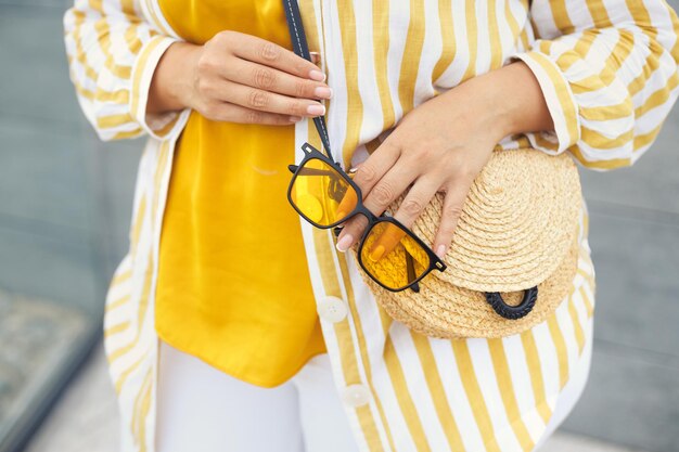 Foto sección media de una mujer con gafas de sol y sombrero