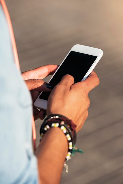 Foto sección media de una mujer joven usando un teléfono móvil