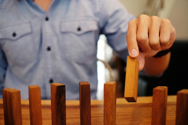 Foto sección media de una mujer jugando al juego de eliminación de bloques en la mesa