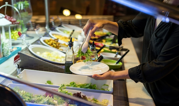 Sección media de una mujer madura que sirve comida en un restaurante