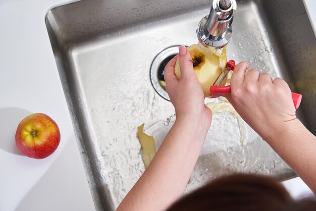 Foto sección media de una mujer con una manzana en casa