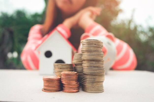 Foto sección media de una mujer con monedas apiladas en la mesa