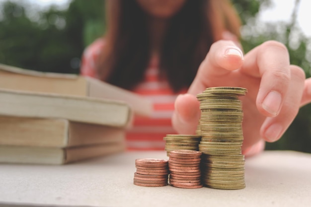 Sección media de una mujer con monedas apiladas en la mesa