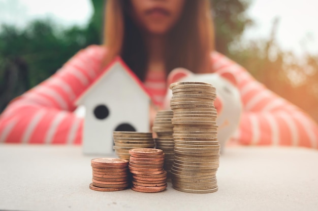 Foto sección media de una mujer con monedas apiladas en la mesa