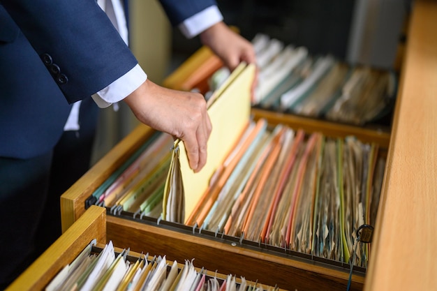 Sección media de una mujer de negocios buscando archivos en el cajón