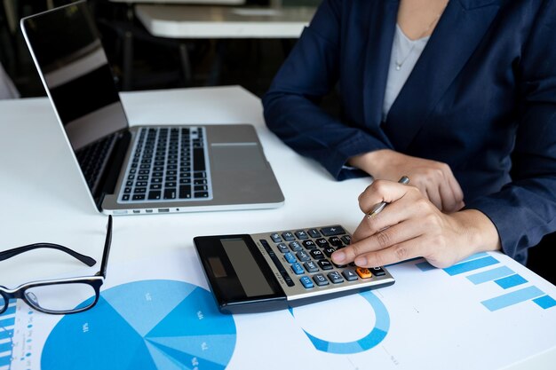 Foto sección media de una mujer de negocios calculando en el escritorio de la oficina