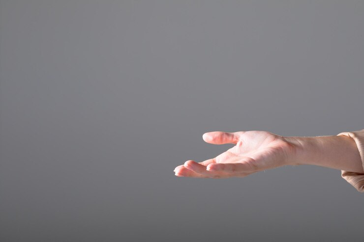 Foto sección media de una mujer de negocios caucásica alcanzando con su mano, aislada sobre fondo gris. concepto de negocio, tecnología, comunicación y crecimiento.