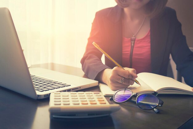 Sección media de una mujer de negocios trabajando en un escritorio en la oficina